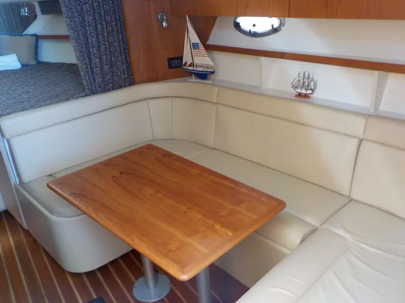Slide: The Image of Interior of 2003 Tiara Yachts 3100 Open with cozy seating and wooden table. - 14