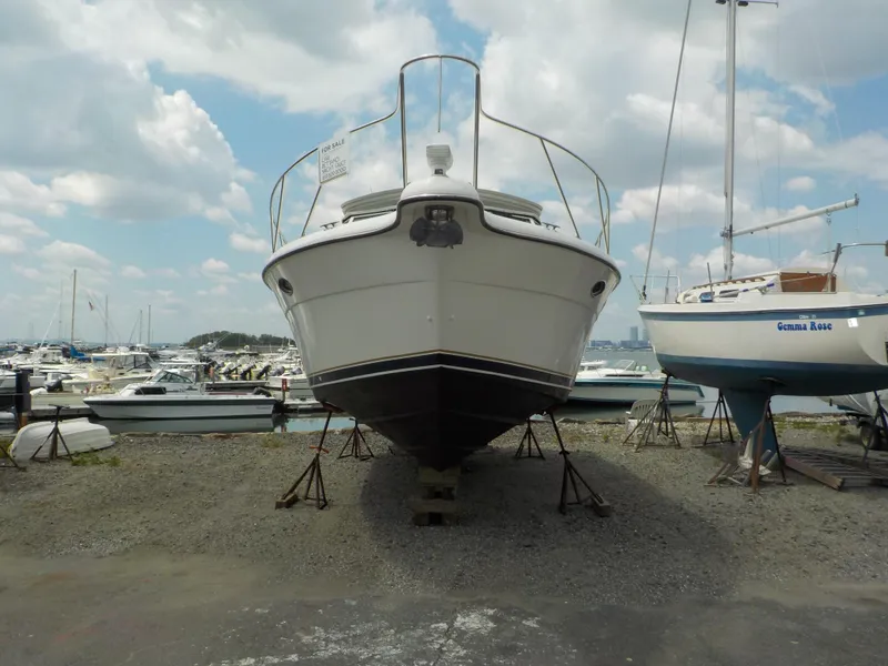 Slide: The Image of 2003 Tiara Yachts 3100 Open on dry dock, marina background, partly cloudy sky. - 3