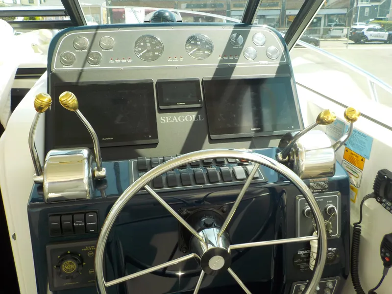 Slide: The Image of 2003 Tiara Yachts 3100 Open helm with steering wheel, controls, and Garmin displays. - 5