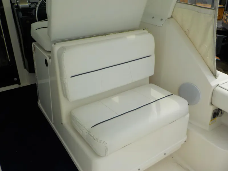 Slide: The Image of 2003 Tiara Yachts 3100 Open interior seating with white upholstery and black accents. - 9