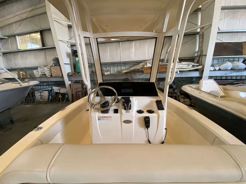 Slide: The Image of 2026 Scout 215 XSF boat interior with steering wheel and control panel in a warehouse. - 4