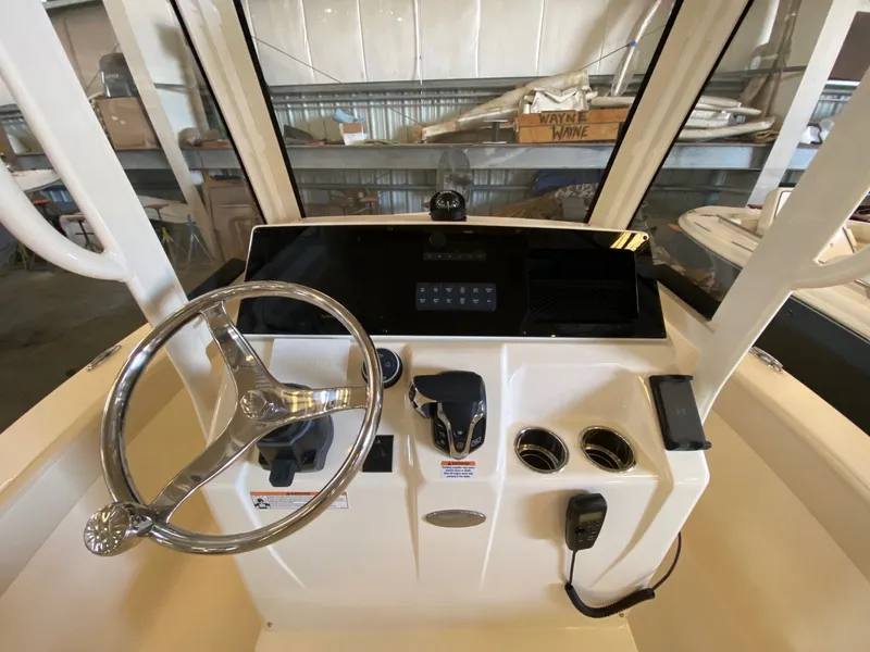Slide: The Image of 2026 Scout 215 XSF boat dashboard with steering wheel and control panel in a showroom. - 5