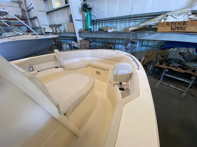 Slide: The Image of 2026 Scout 215 XSF boat interior with cushioned seating in a storage facility. - 6