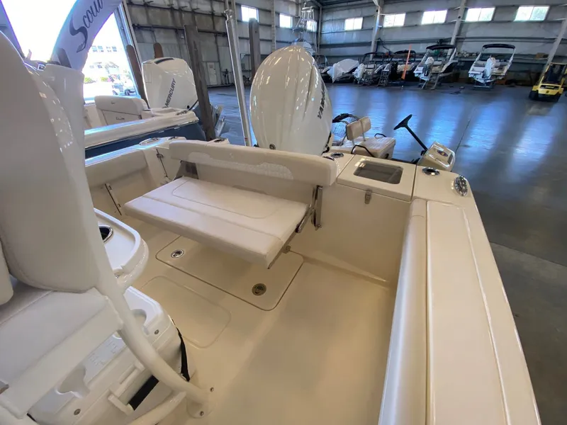 Slide: The Image of 2026 Scout 215 XSF boat interior with seating and storage in a showroom. - 9