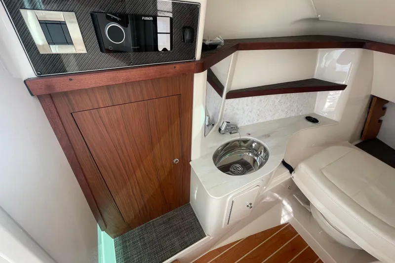 Slide: The Image of 2026 Grady-White Freedom 325 cabin interior with sink, wooden door, and seating area. - 10