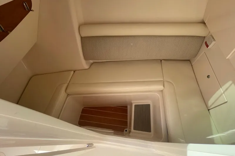 Slide: The Image of 2026 Grady-White Freedom 325 cabin interior with beige seating and wood flooring. - 11