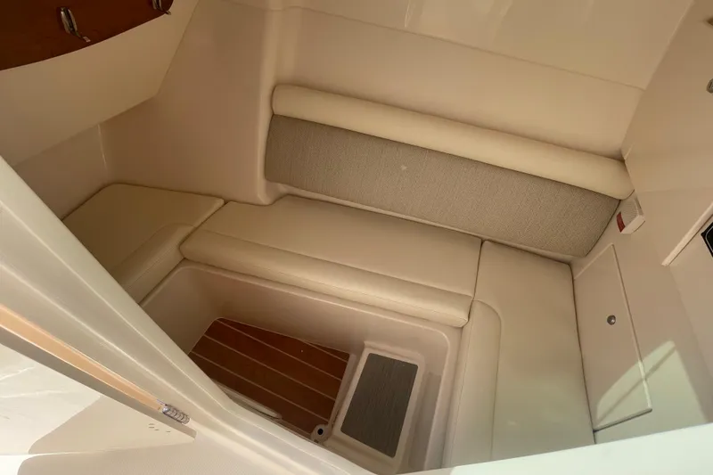 Slide: The Image of 2026 Grady-White Freedom 325 boat interior with cushioned seating and wooden flooring. - 12