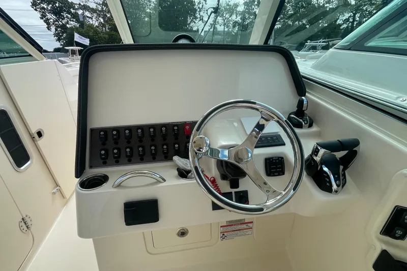 Slide: The Image of 2026 Grady-White Freedom 325 helm with steering wheel and control panel. - 5