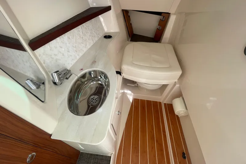 Slide: The Image of 2026 Grady-White Freedom 325 boat interior with sink, toilet, and wooden flooring. - 8