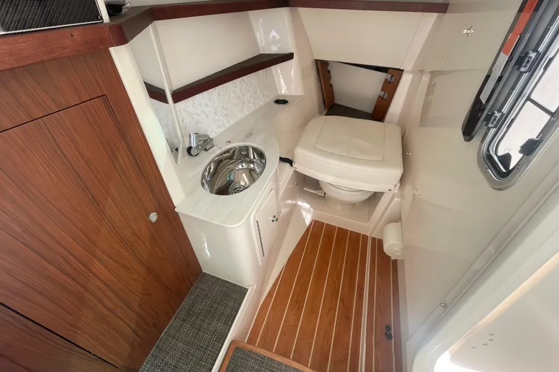 Slide: The Image of 2026 Grady-White Freedom 325 boat interior with sink, toilet, and wood accents. - 9