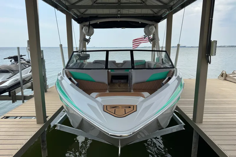 Slide: The Image of 2022 Tigé Z3 boat covered and docked on a lift by the lake. - 4