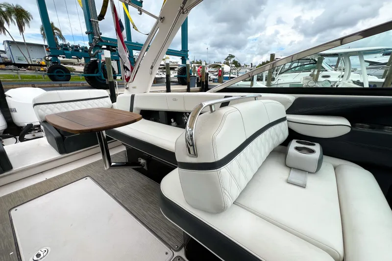 Slide: The Image of 2019 Regal 29 OBX boat interior with white seating and wooden table. - 13