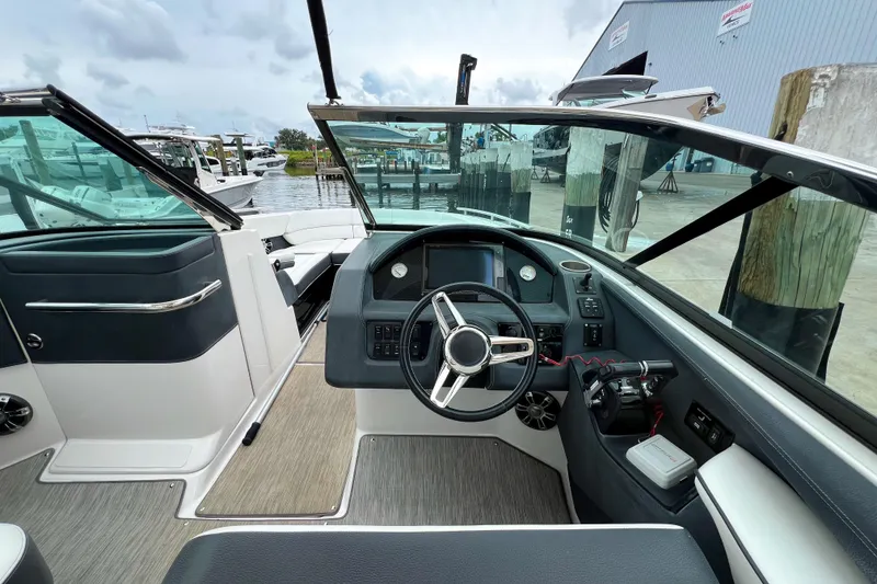 Slide: The Image of 2019 Regal 29 OBX boat cockpit with steering wheel and dashboard, docked at marina. - 15