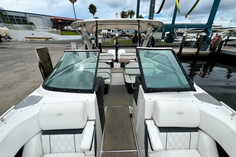 Slide: The Image of 2019 Regal 29 OBX boat with white seating, docked at a marina. - 19