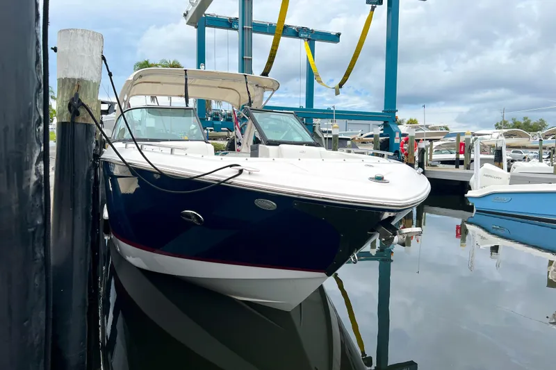 Slide: The Image of 2019 Regal 29 OBX boat docked at marina, reflecting on calm water. - 2