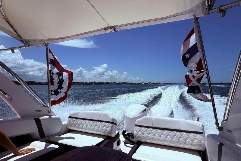 Slide: The Image of 2019 Regal 29 OBX boat cruising on open water under clear blue skies. - 6
