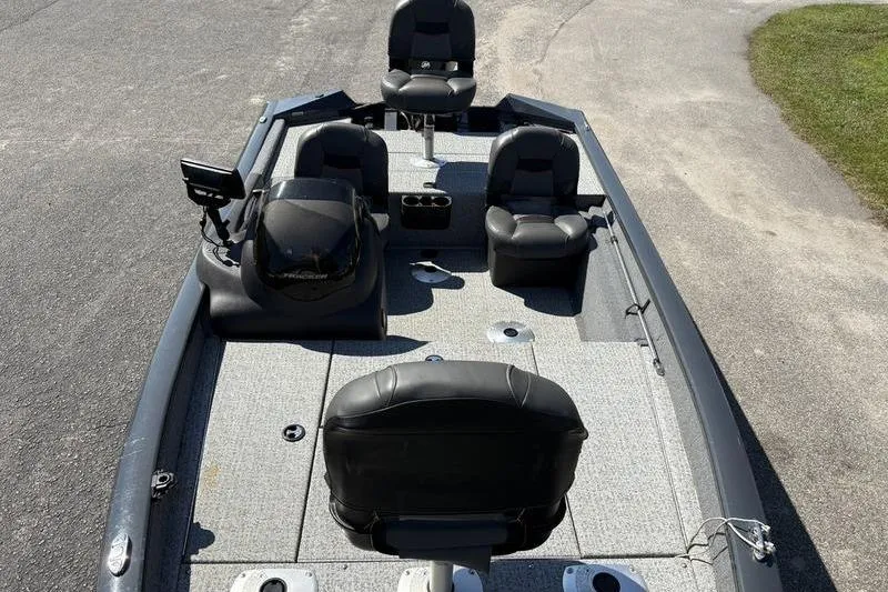 Slide: The Image of 2022 Tracker Pro Team 175 TF fishing boat with seating and console, parked on pavement. - 14