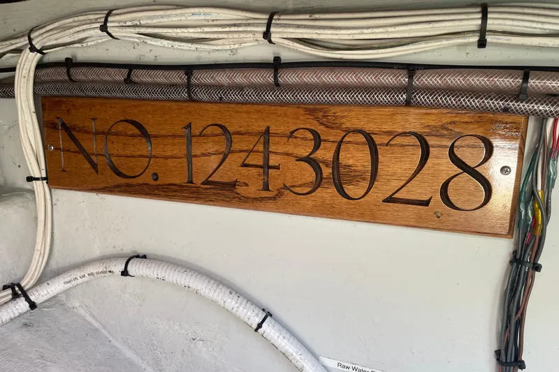 Slide: The Image of Wooden plaque with "No. 1243028" on a 2012 Hunt Surfhunter boat interior. - 11