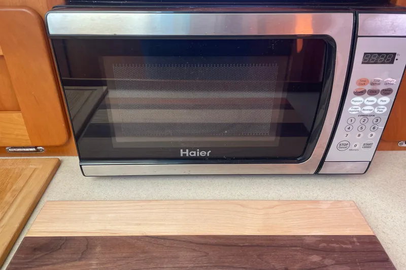 Slide: The Image of Haier microwave in a 2012 Hunt Surfhunter kitchen, with wooden cabinetry and countertop. - 15