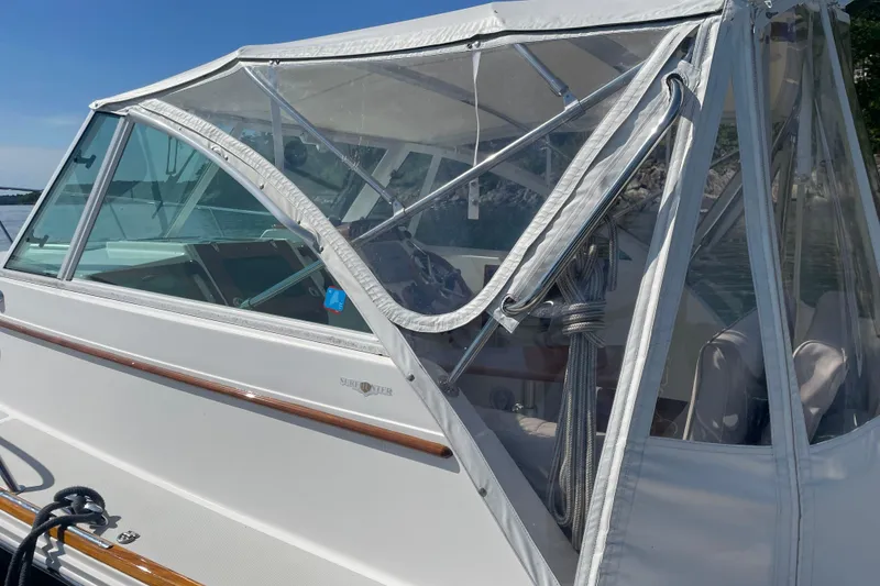 Slide: The Image of 2012 Hunt Surfhunter boat with white canopy and clear windows on a sunny day. - 8