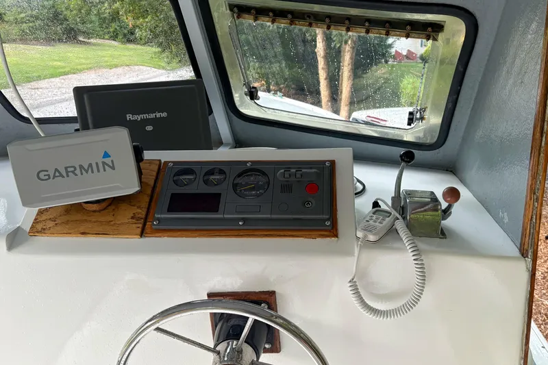 Slide: The Image of 1980 SISU 26 boat dashboard with Garmin and Raymarine navigation systems. - 11