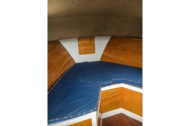 Slide: The Image of 1980 SISU 26 boat interior with blue cushioned seating and wooden paneling. - 12