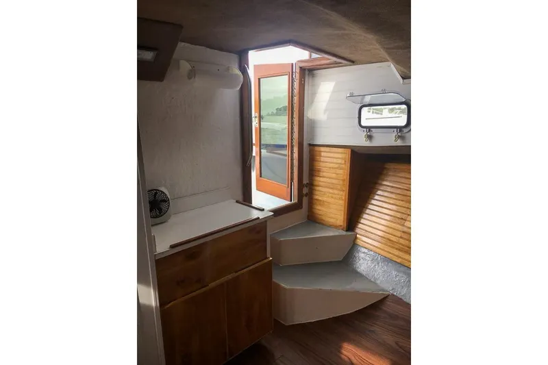 Slide: The Image of Interior of 1980 SISU 26 boat with wooden cabinetry and steps leading to deck. - 15
