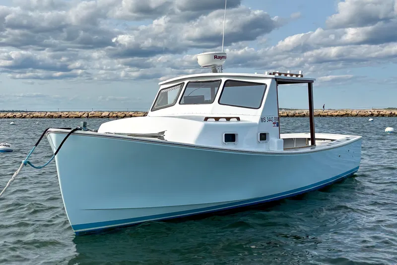 Slide: The Image of 1980 SISU 26 boat on water, clear sky, rocky shoreline in background. - 4