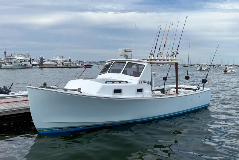 Slide: The Image of 1980 SISU 26 boat docked with fishing rods, calm harbor background. - 6