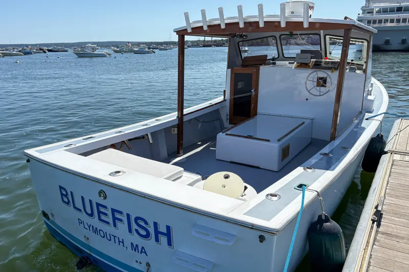 Slide: The Image of 1980 SISU 26 boat named "Bluefish" docked in Plymouth, MA harbor. - 9