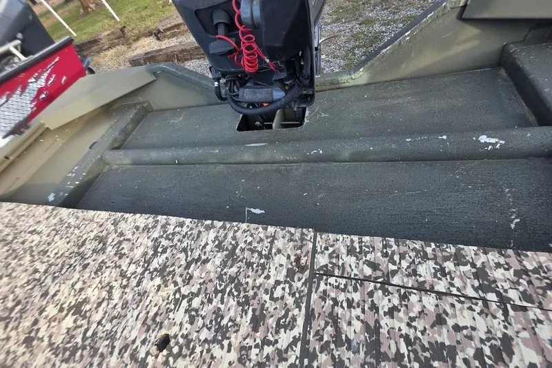 Slide: The Image of 2018 Tracker Grizzly 1648 boat interior with camouflage flooring and motor. - 12