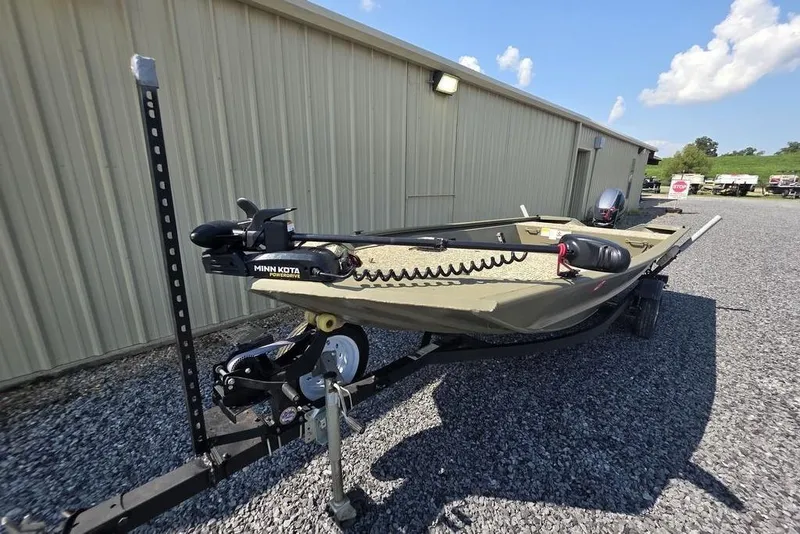 Slide: The Image of 2018 Tracker Grizzly 1648 boat with Minn Kota trolling motor, parked on gravel. - 5