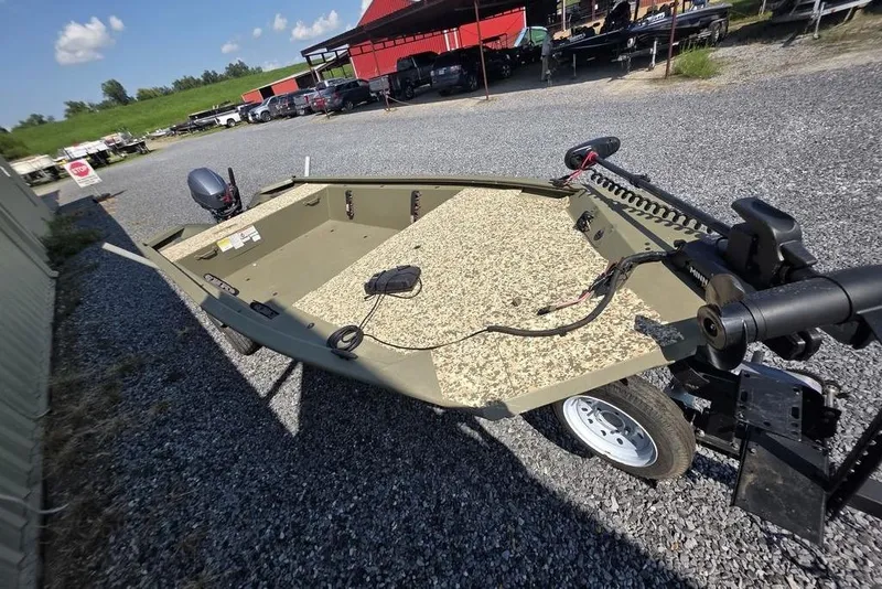Slide: The Image of 2018 Tracker Grizzly 1648 boat on gravel lot with motor and trailer. - 9