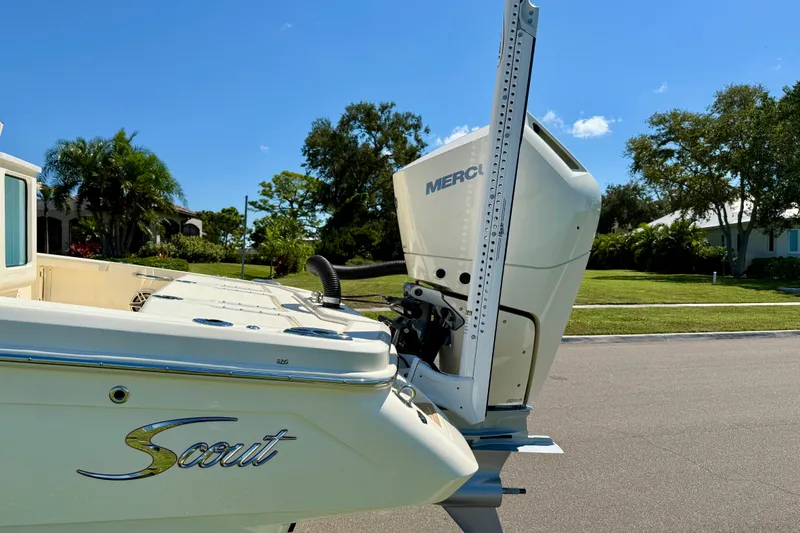 Slide: The Image of 2025 Scout 261 XSS boat with Mercury engine, parked on a sunny street. - 10
