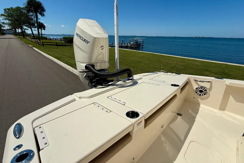 Slide: The Image of 2025 Scout 261 XSS boat with Mercury engine by a scenic waterfront. - 11