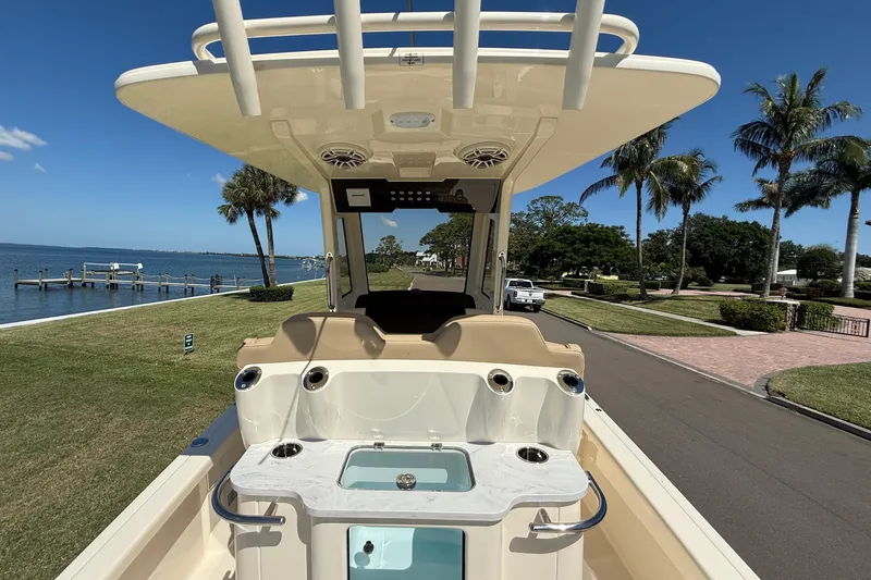 Slide: The Image of 2025 Scout 261 XSS boat with sleek design, docked near waterfront, palm trees in background. - 13