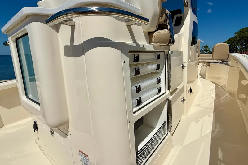Slide: The Image of 2025 Scout 261 XSS boat interior with storage compartments and seating under clear blue sky. - 19