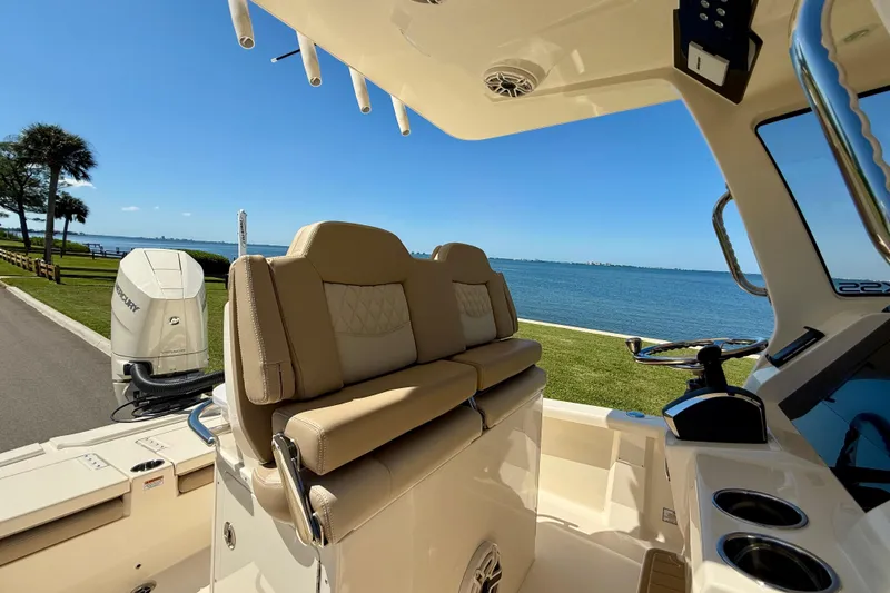 Slide: The Image of 2025 Scout 261 XSS boat interior with seating, overlooking a scenic waterfront view. - 20