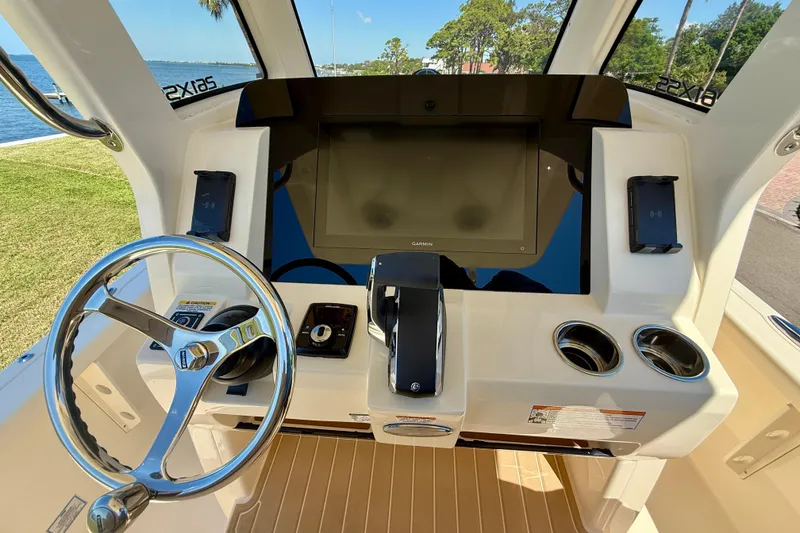 Slide: The Image of 2025 Scout 261 XSS boat helm with steering wheel, touchscreen, and controls. - 24