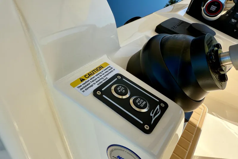 Slide: The Image of Control panel of 2025 Scout 261 XSS boat with caution label and jack plate buttons. - 26