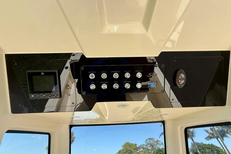 Slide: The Image of Control panel of 2025 Scout 261 XSS boat with various switches and display. - 27