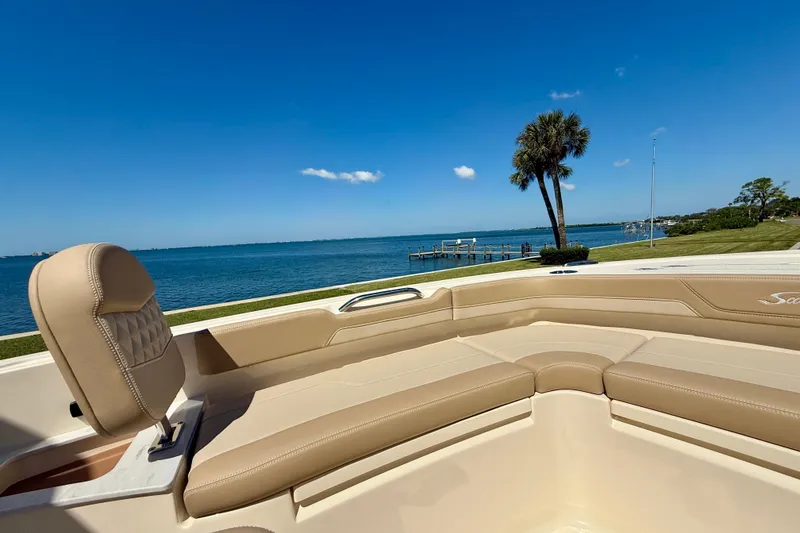 Slide: The Image of 2025 Scout 261 XSS boat interior with beige seating, overlooking a serene waterfront view. - 31