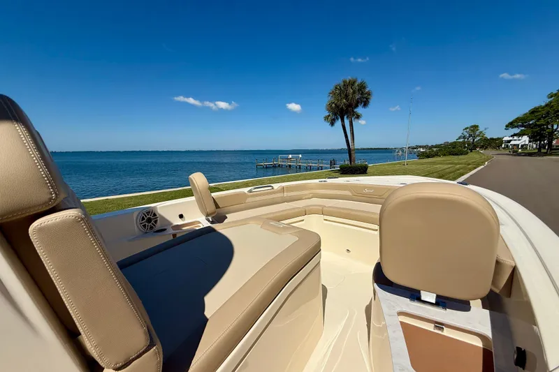 Slide: The Image of 2025 Scout 261 XSS boat interior with scenic waterfront view and clear blue sky. - 32