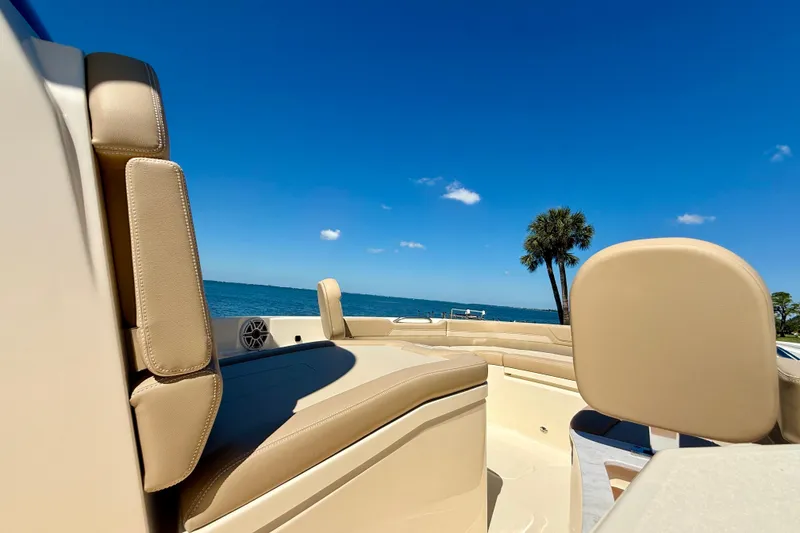 Slide: The Image of 2025 Scout 261 XSS boat interior with beige seating, ocean view, and clear blue sky. - 34