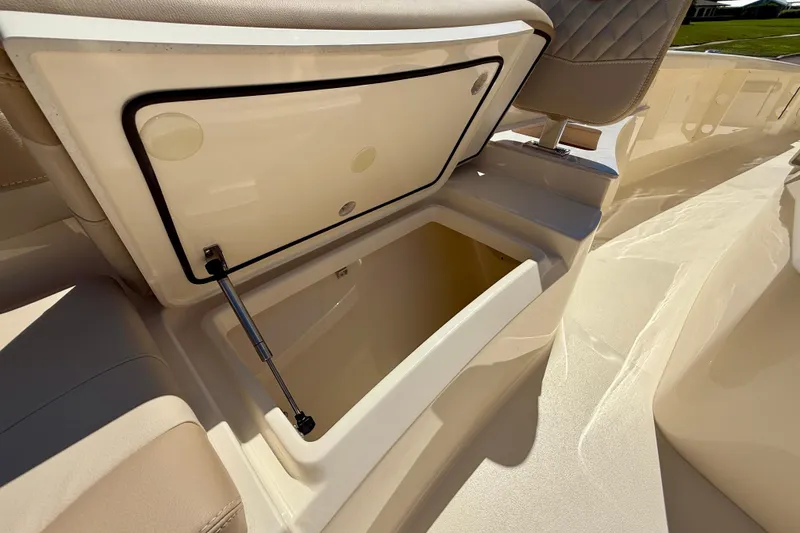 Slide: The Image of 2025 Scout 261 XSS boat storage compartment with open lid, showcasing spacious interior. - 38