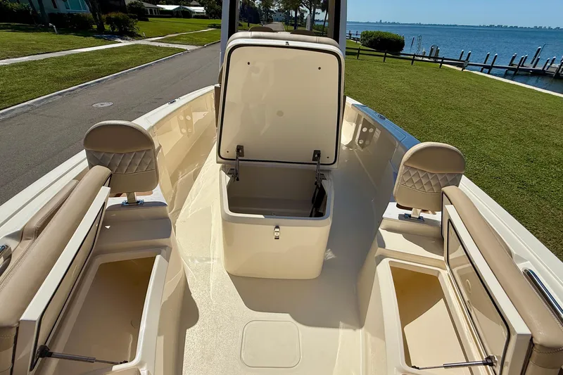 Slide: The Image of 2025 Scout 261 XSS boat interior with open storage compartments, dockside view. - 39