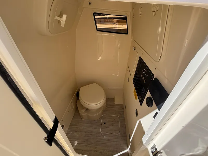 Slide: The Image of 2025 Scout 261 XSS boat interior bathroom with toilet and window. - 42