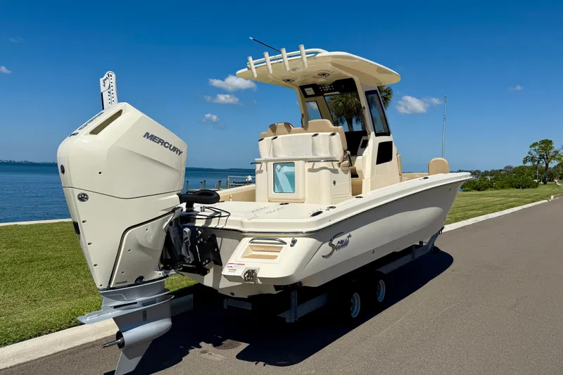 Slide: The Image of 2025 Scout 261 XSS boat with Mercury engine, parked by a scenic waterfront. - 7