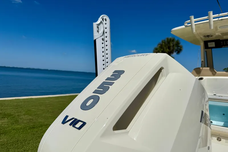 Slide: The Image of 2025 Scout 261 XSS boat with Mercury 350 V10 engine by the water. - 9