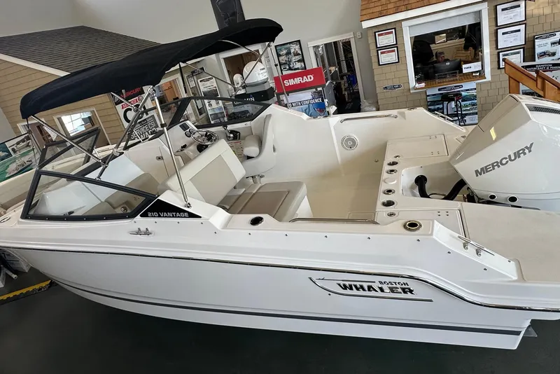 The Image of 2026 Boston Whaler 210 Vantage boat with Mercury engine in showroom display. - 0